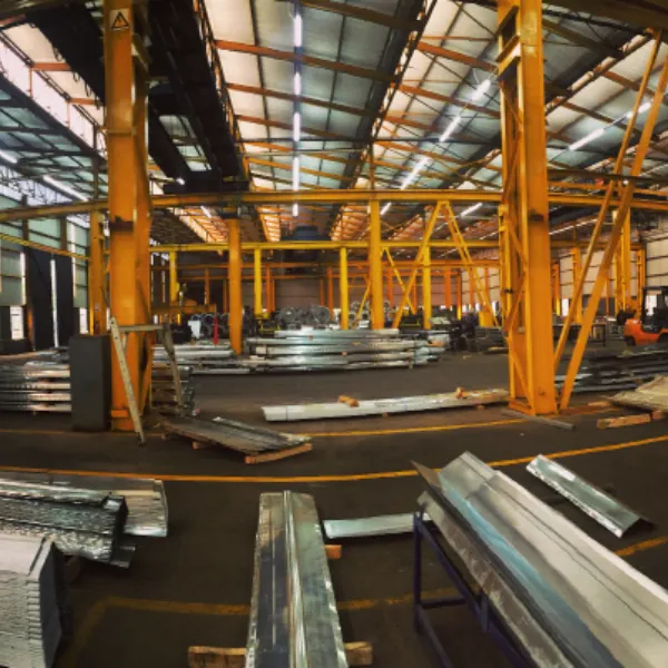 Inside the Roofco factory: yellow portal frames over stacked roll-formed steel profiles